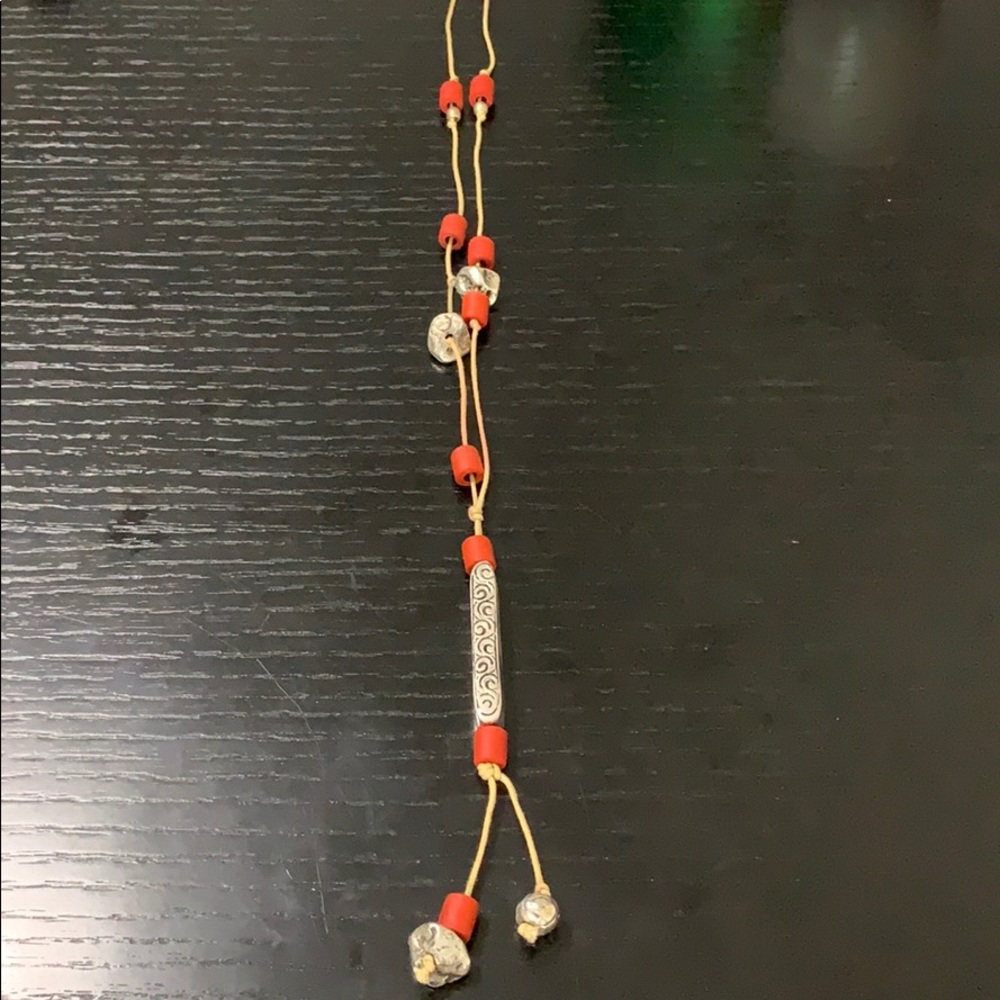 Necklace with orange/red tones and silver pendant